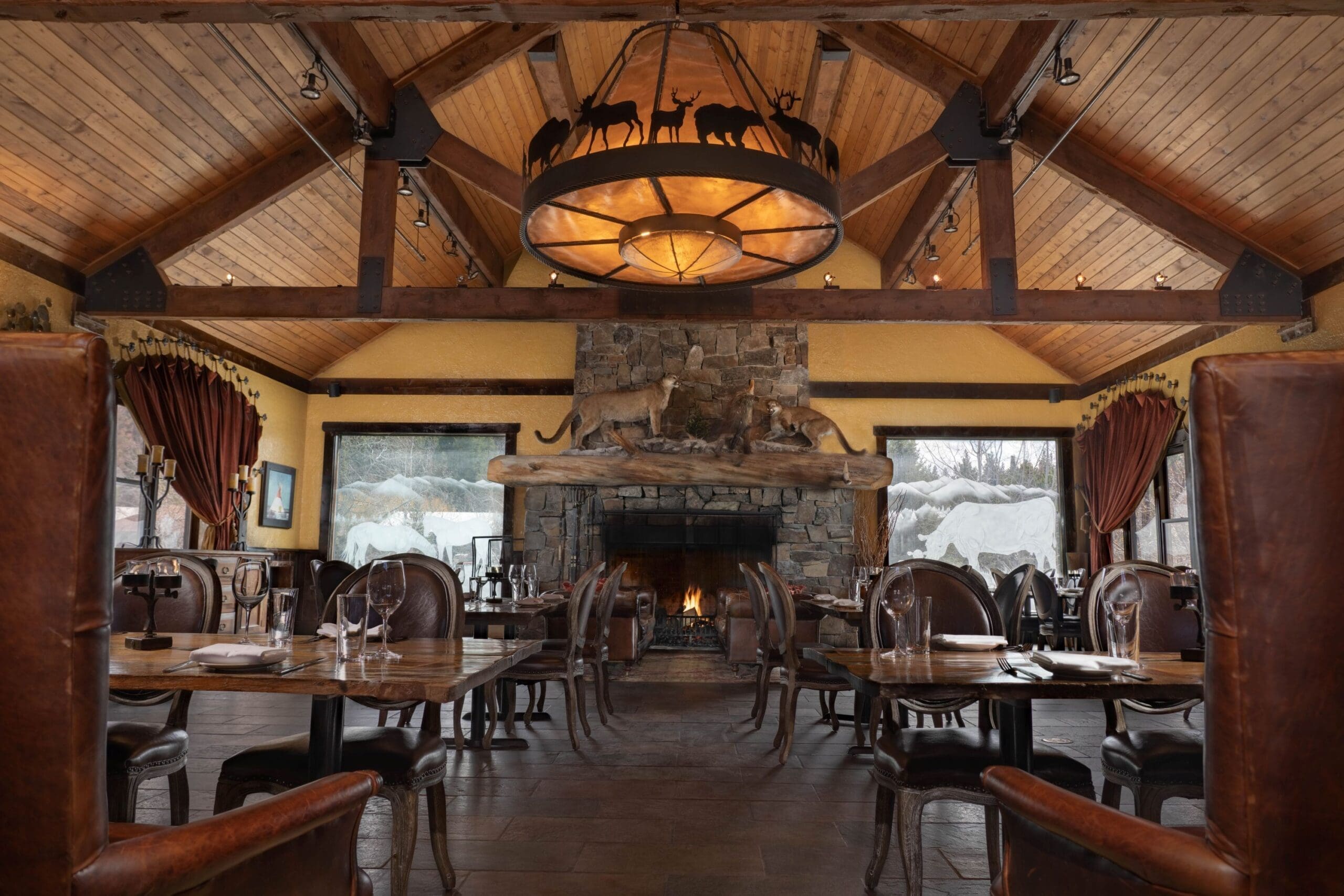 Indoor view of Pomp, the luxury restaurant at Paws Up, with high wooden-paneled ceilings and luxurious leather seating