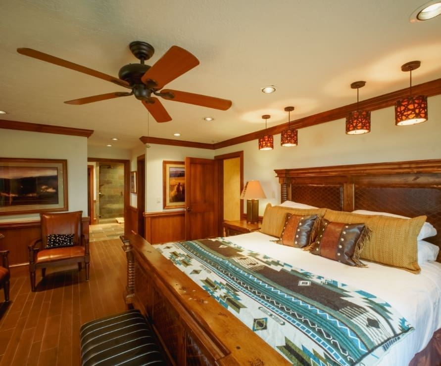 Inside view of a bedroom in a Wilderness Estate, featuring a king-sized bed with western-themed bedding