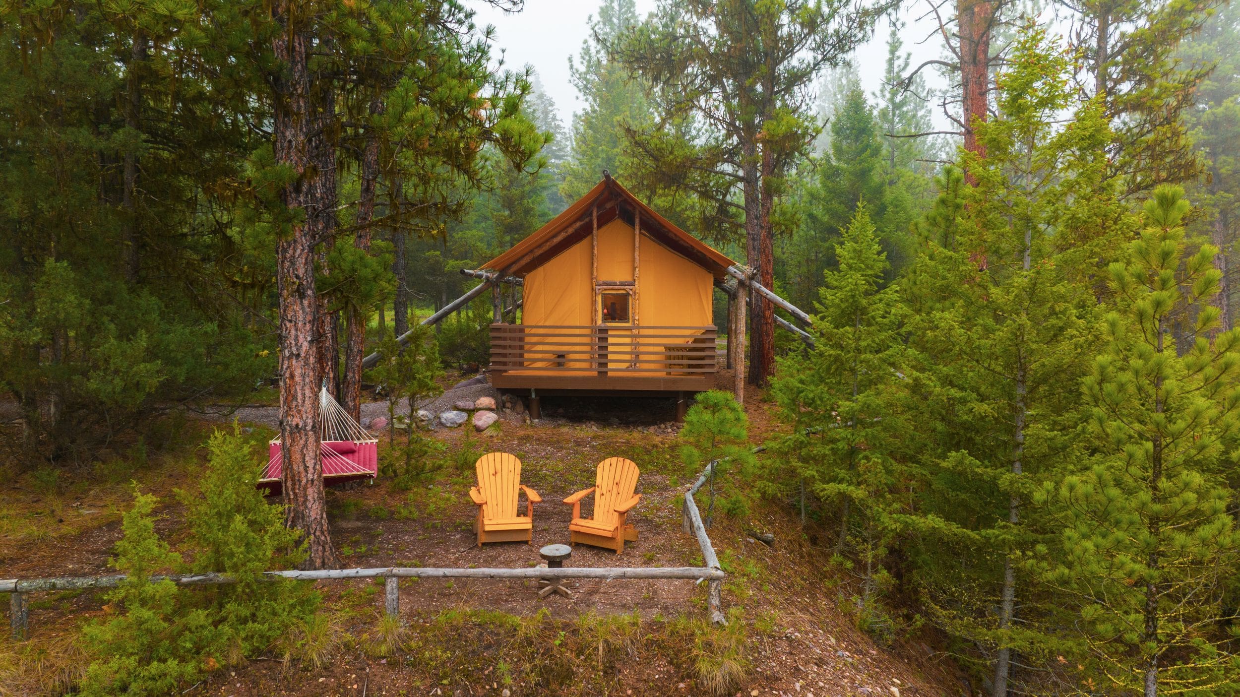 Exterior of luxury canvas glamping tent with porch and hammock