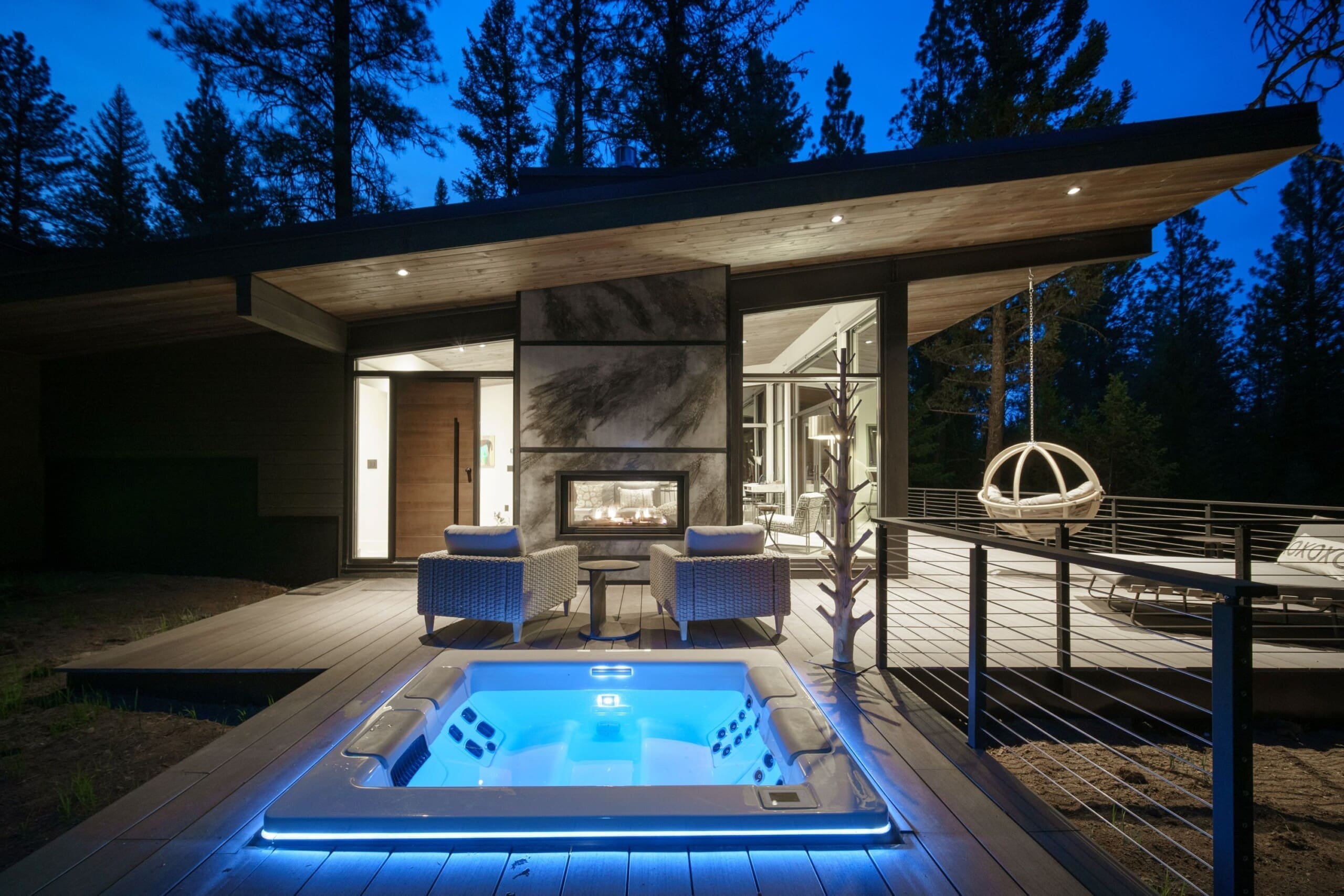Exterior of modern cabin with swing and hot tub