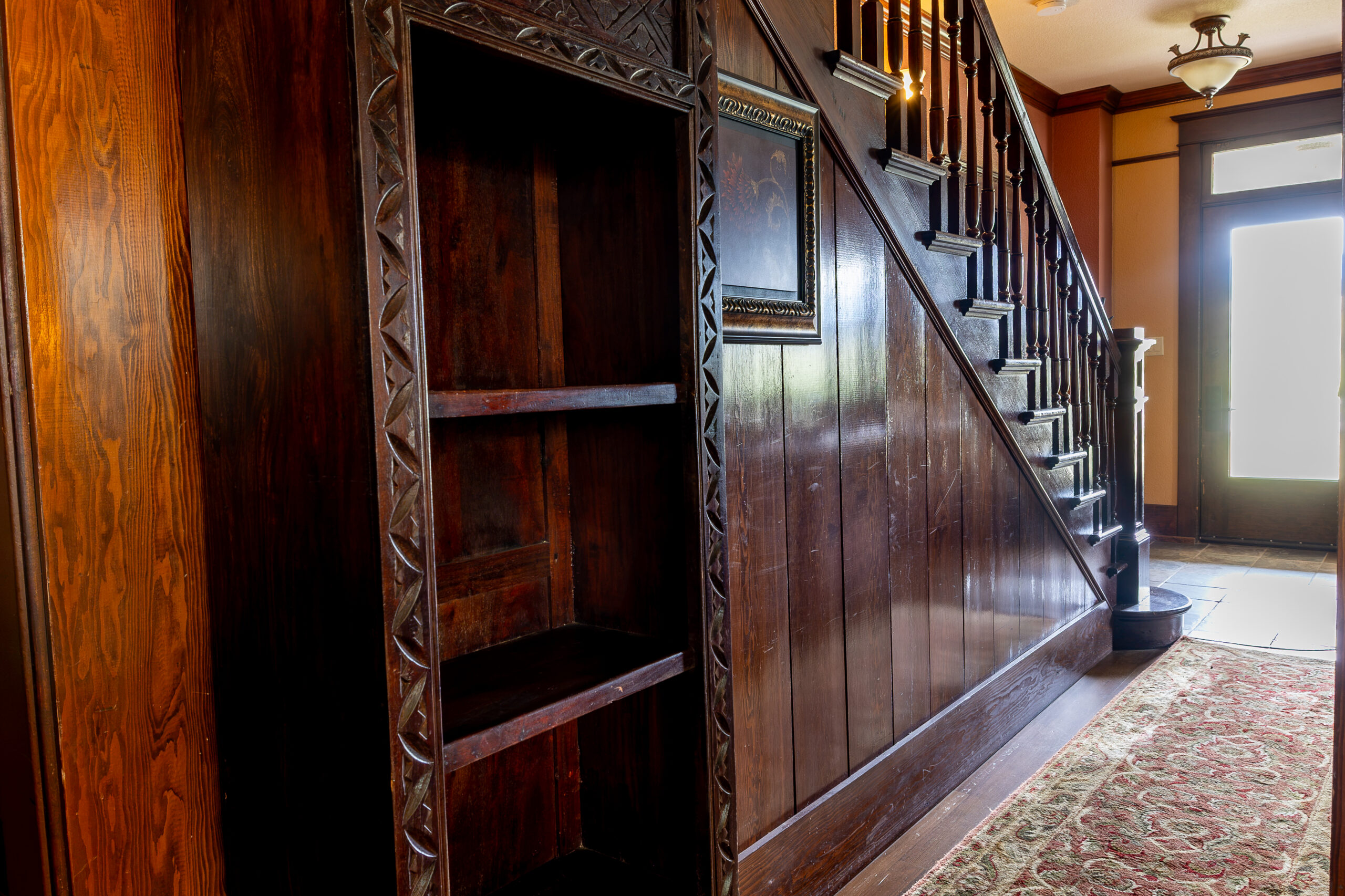 Dark wooden staircase near an entry way.
