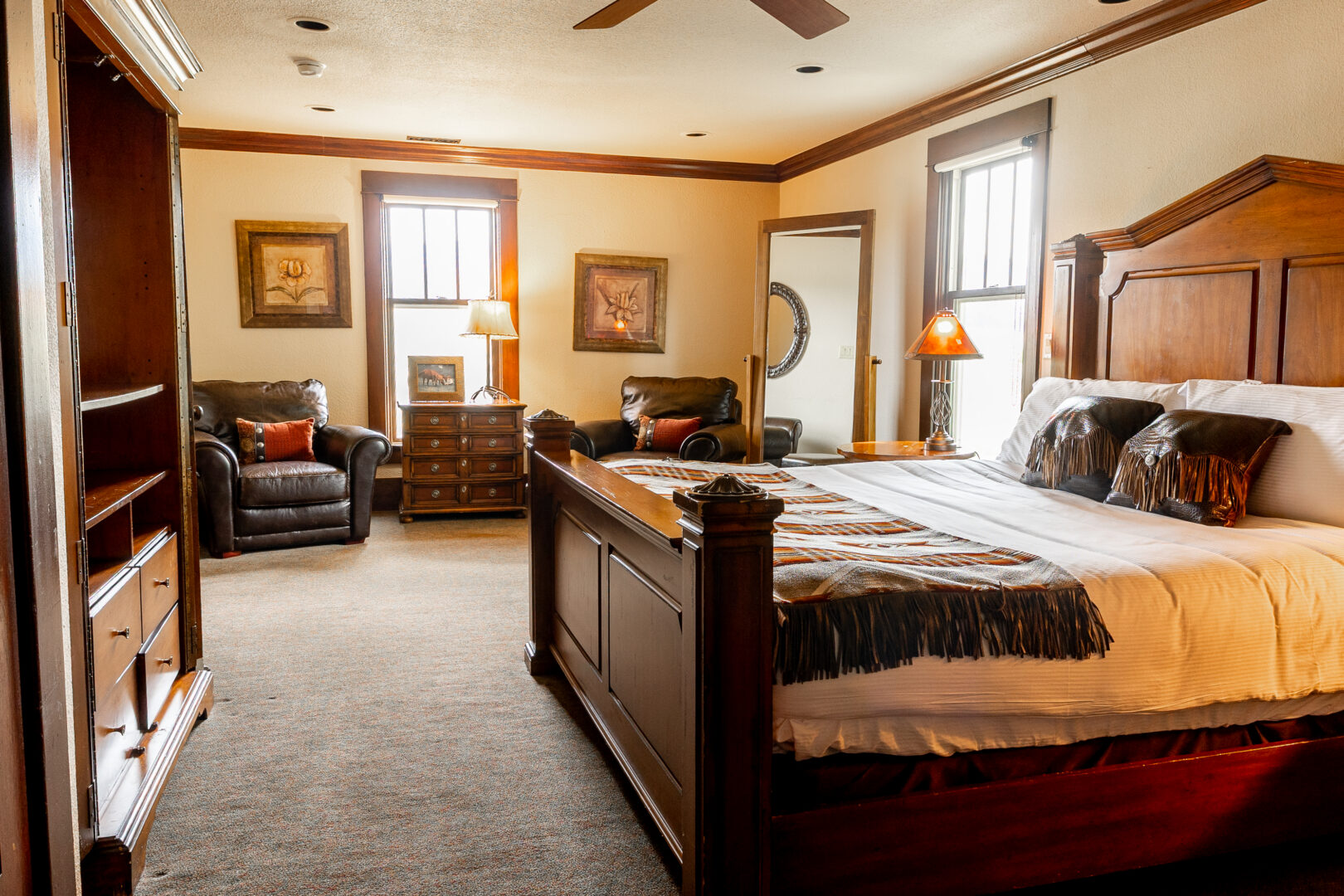 Western looking bedroom with a bed on a wooden platform and a dark colored chair in the corner.