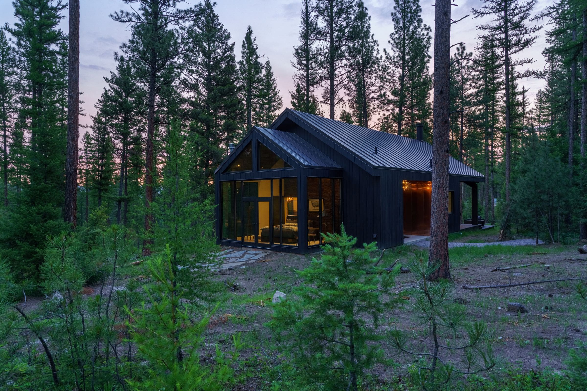 Exterior of modern cabin with window walls in the forest