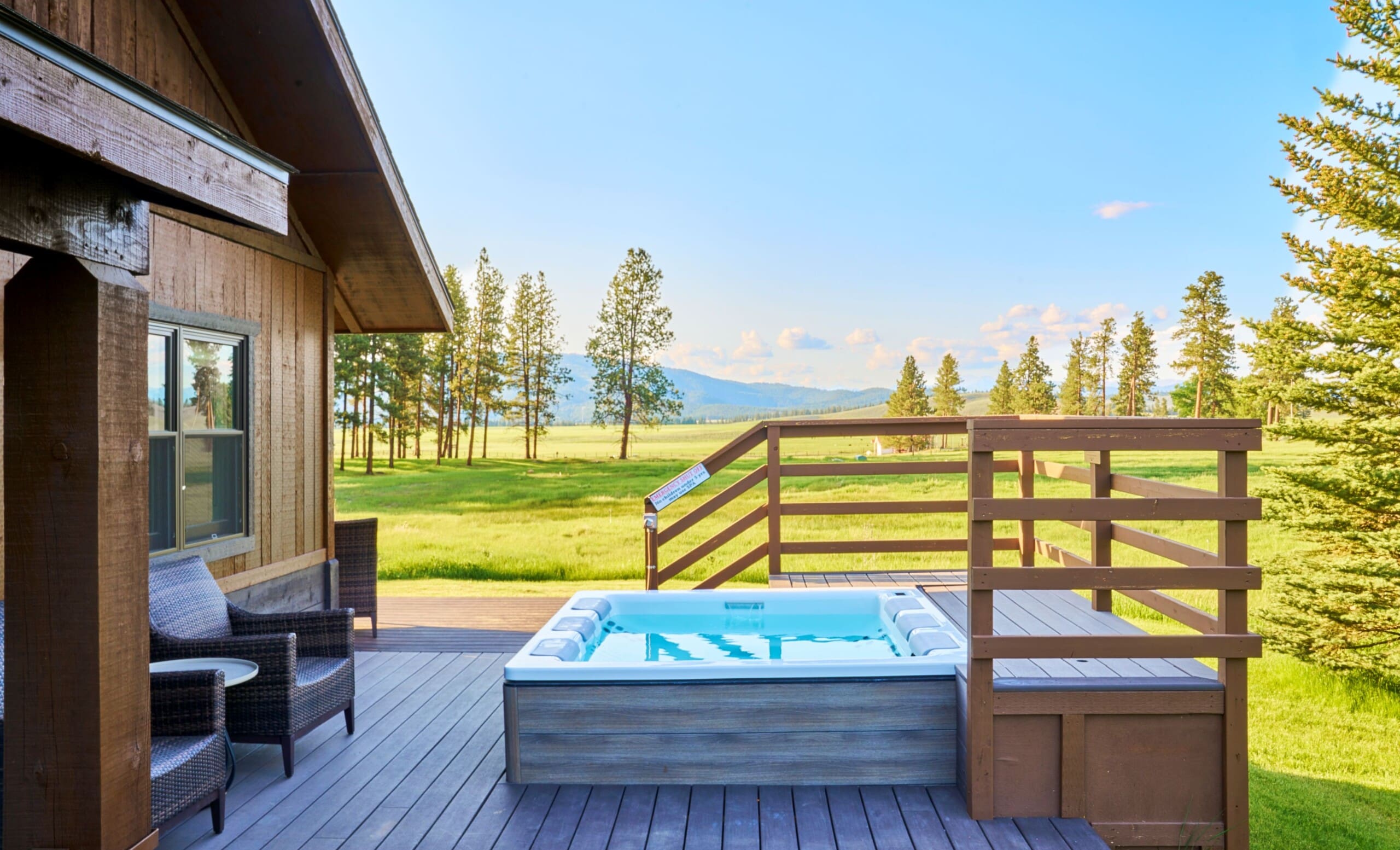 exterior of cabin porch with hot tub and meadow view