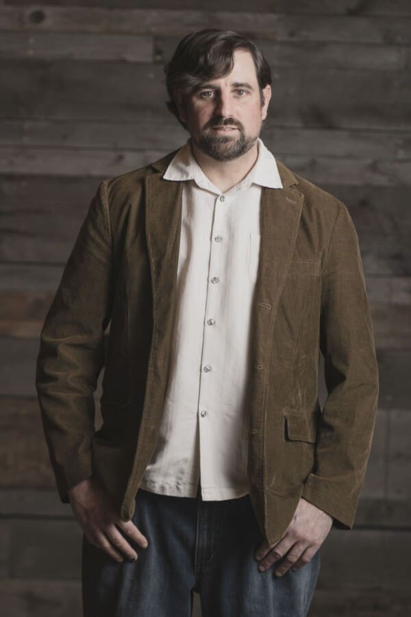 Chef Bret posing in a brown jacket and white button up