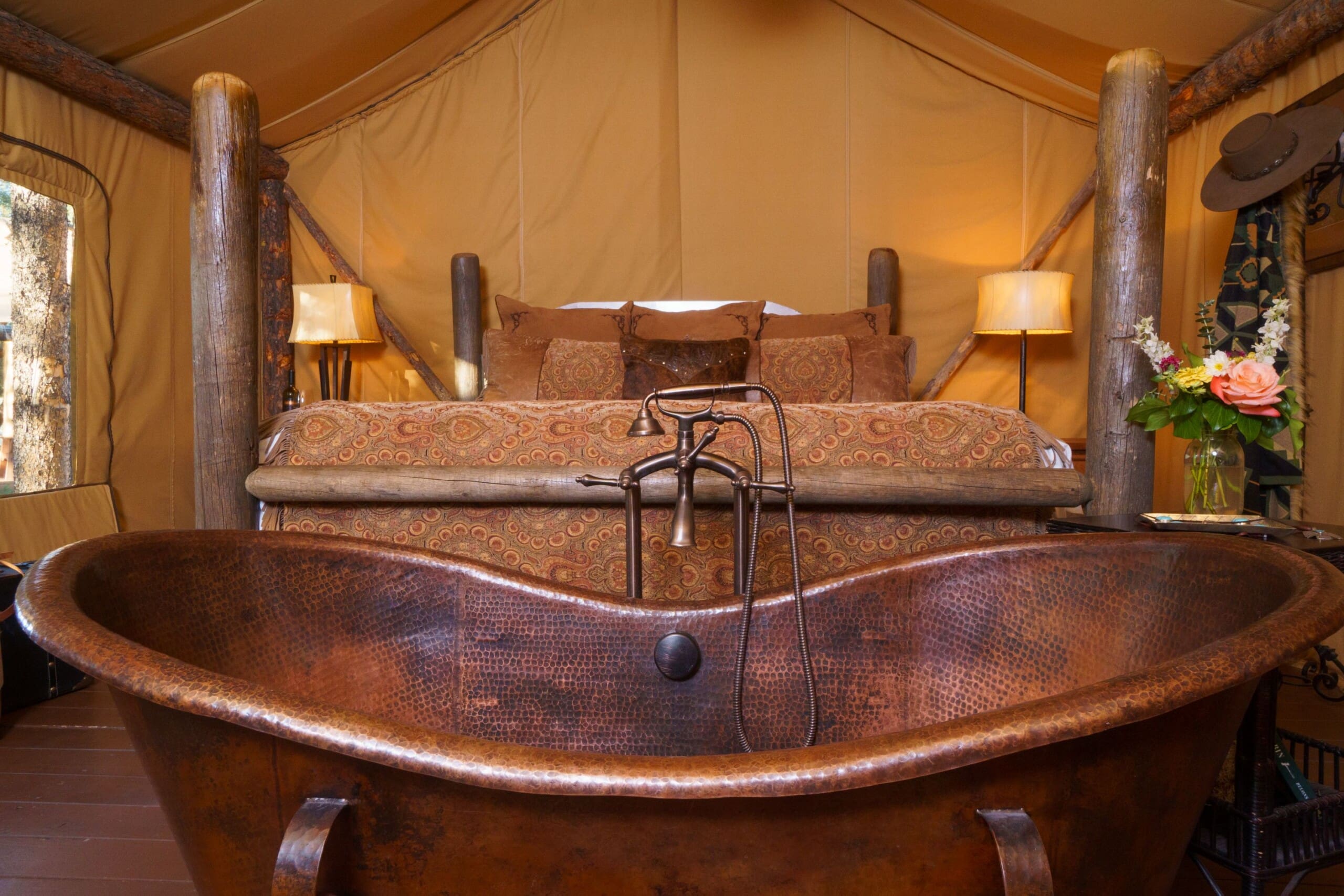 Copper bathtub and king size bed in canvas glamping tent