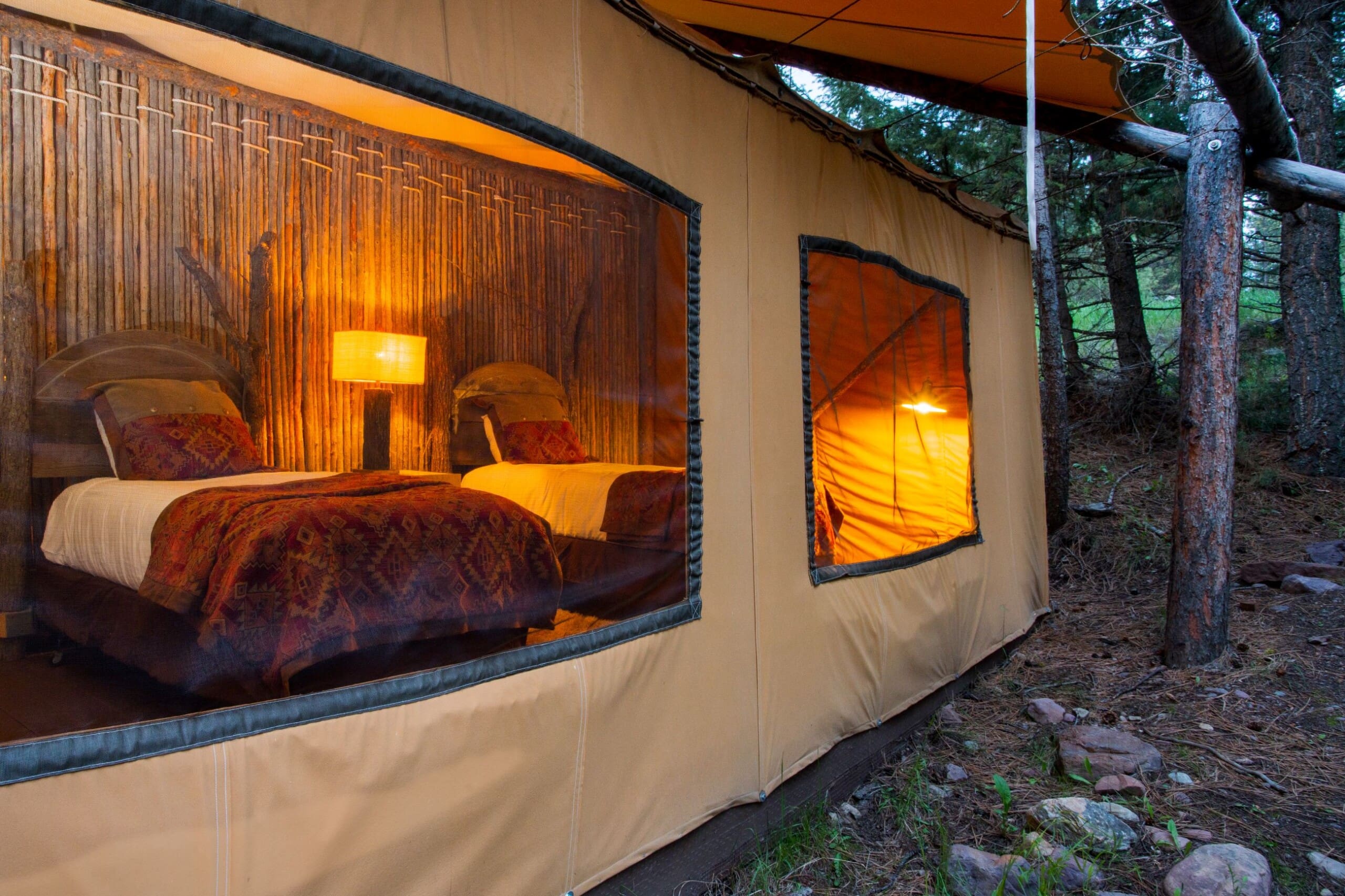 Two twin beds inside of a canvas glamping tent