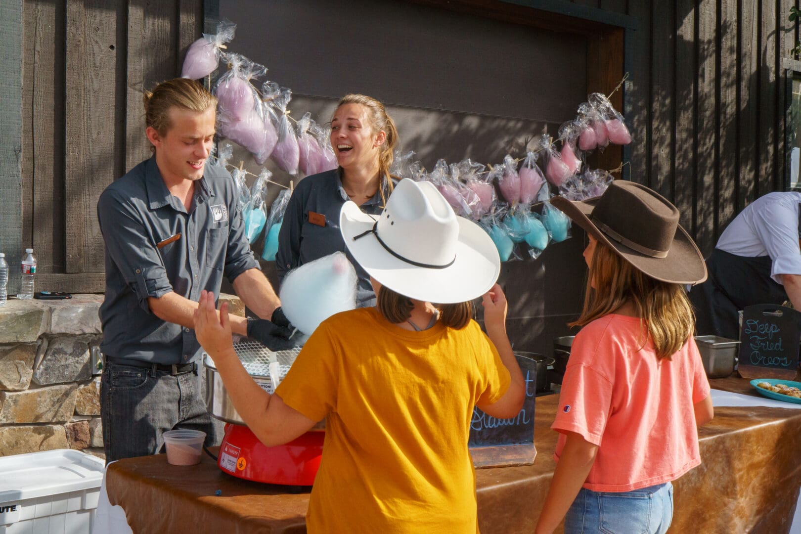 Two workers talking to children at a festival.