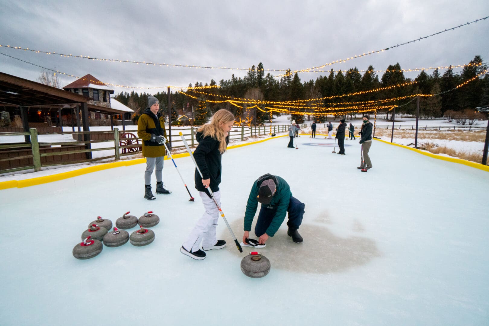 Family curling on an ice skating rink.
