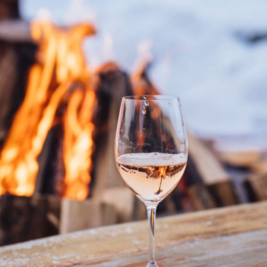 Wine glass by an outdoor fire.