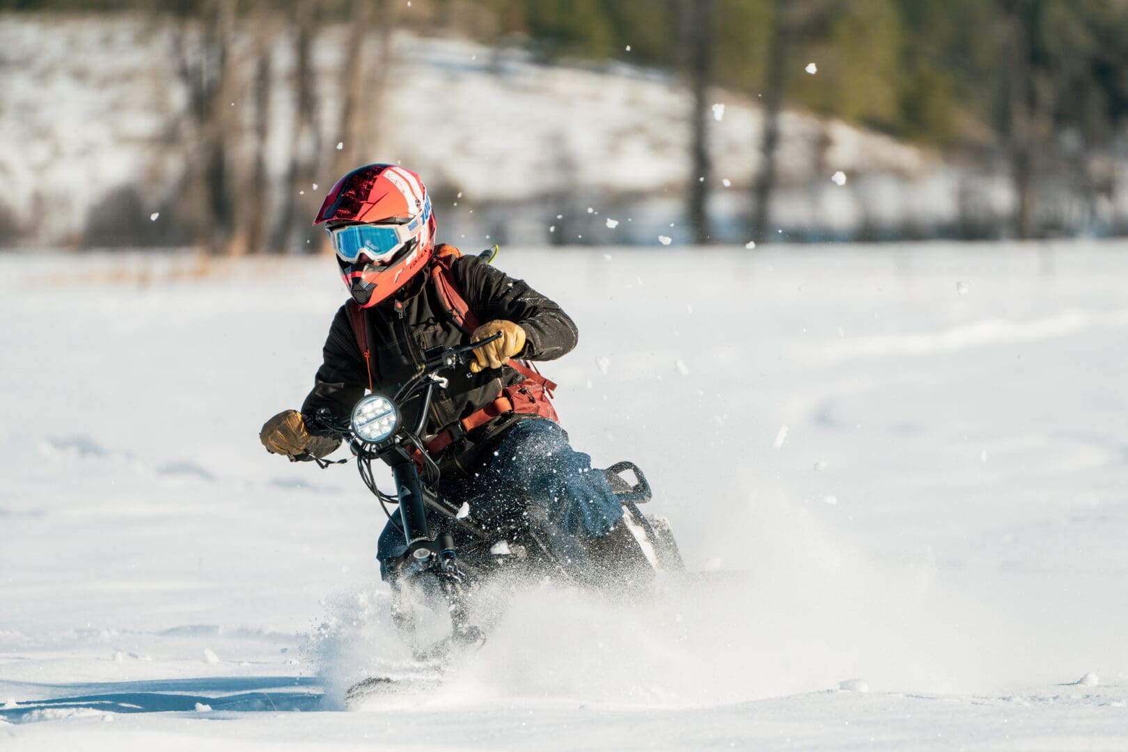 Man in orange helmet and winter gear on a moon book during the winter.
