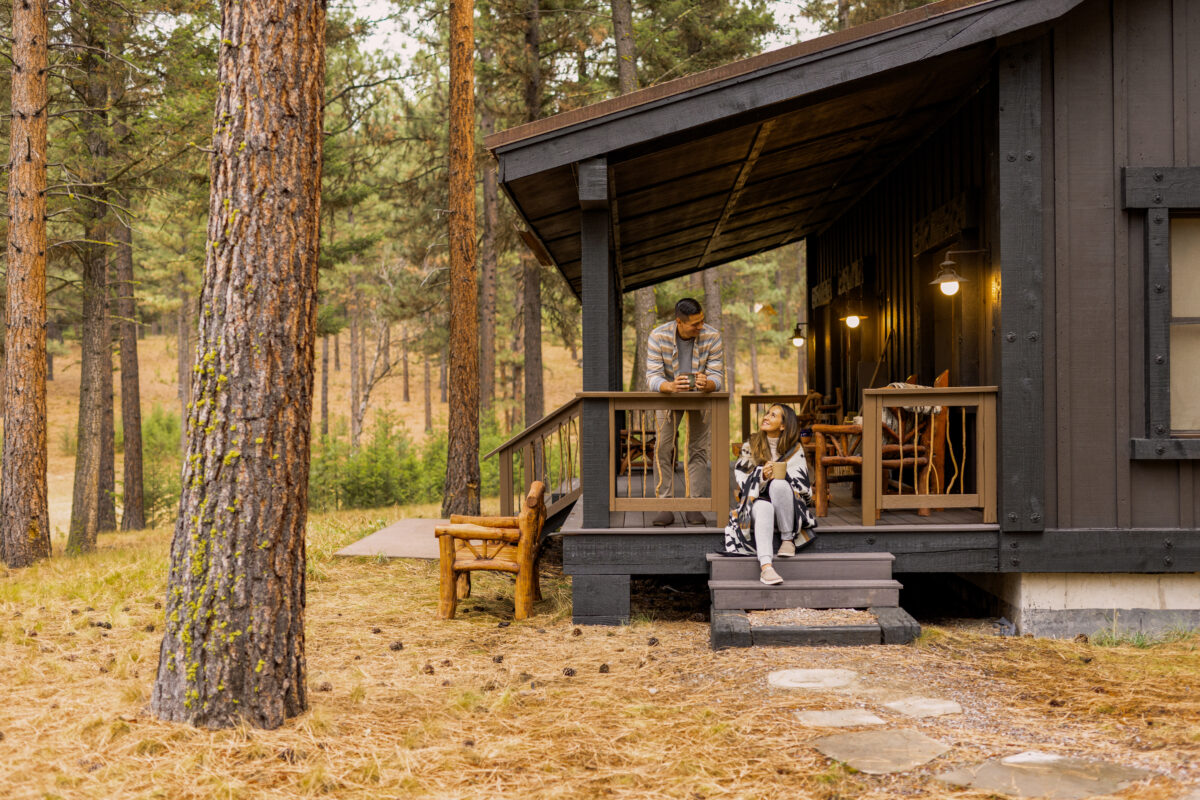 Couple on the porch at a cabin in Montana wilderness.