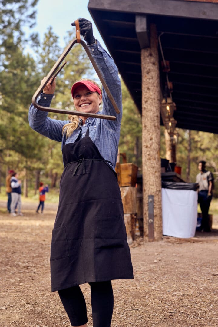 Female chef holding a musical triangle.