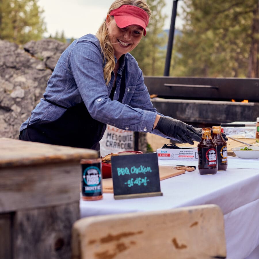 A female chef making pizzas at an outdoor event.