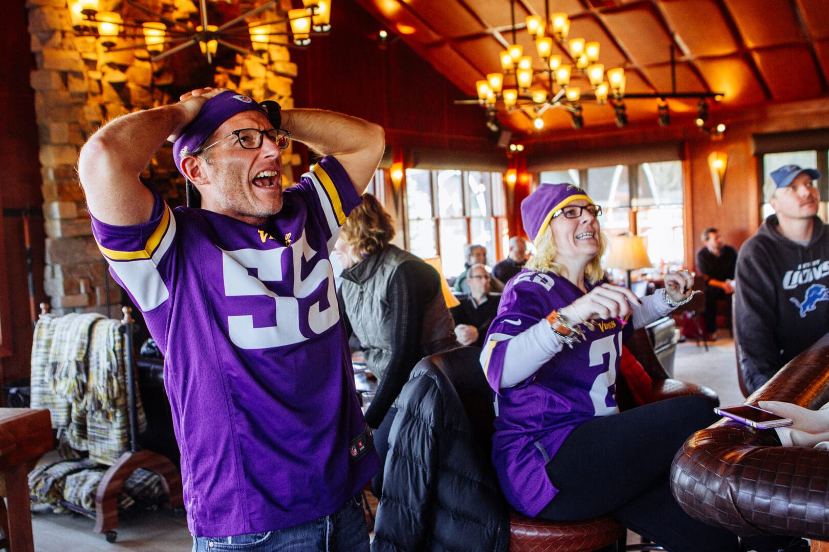 Group of vikings football fans cheering while a game is on.