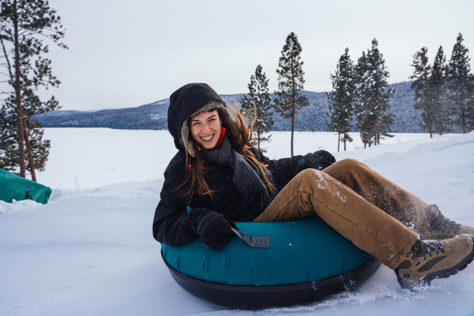 One lady tubing down a snowy hill.