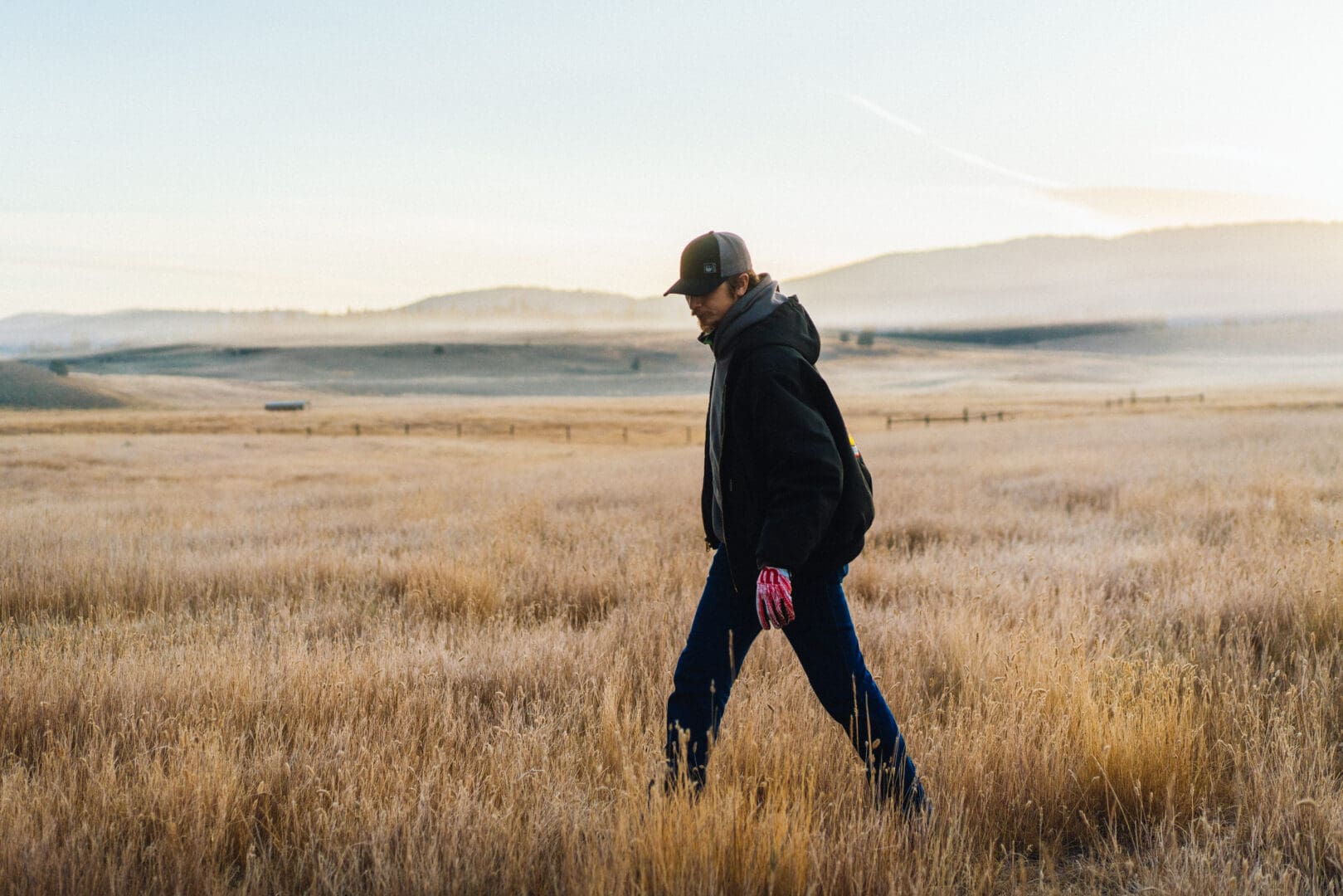 Man walking alone in a dry field.