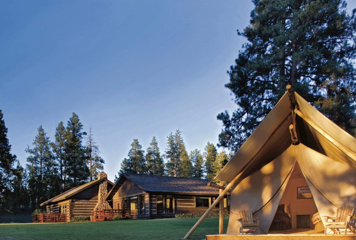Tent with a wooden log hose behind it.