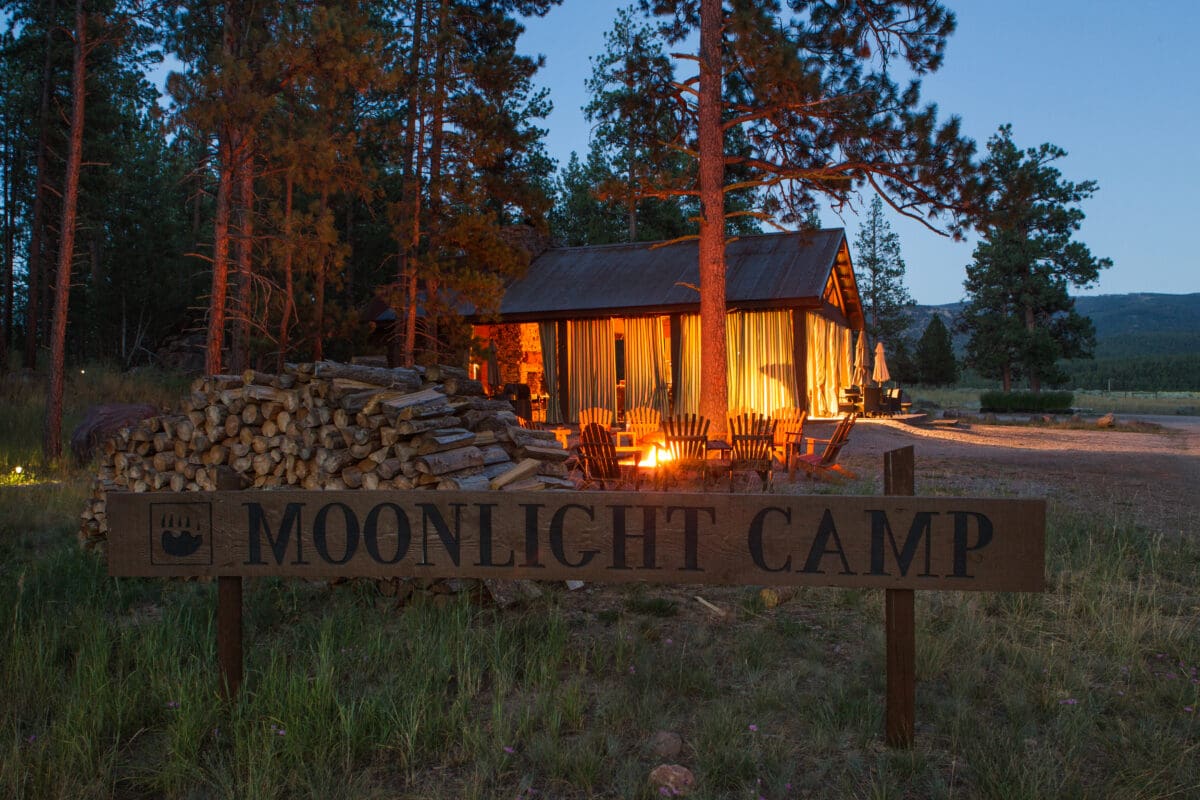 Glowy pavilion at night with a sign in front of it titled "Moonlight Camp"