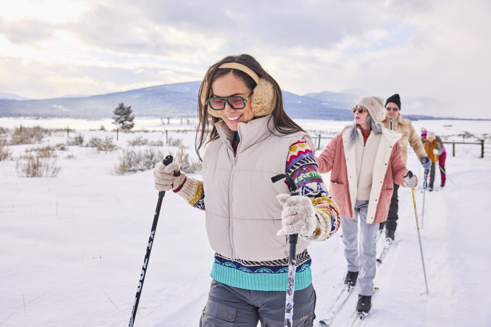 Group of friends cross country skiing outside on a snowy landscape.
