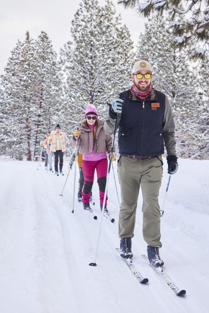 Group of friends cross country skiing outside on a snowy landscape.