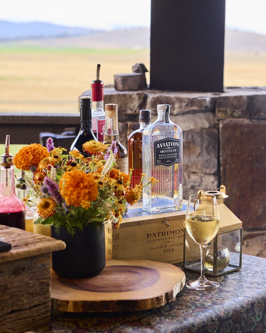 Wine and liquor and na table with flowers.