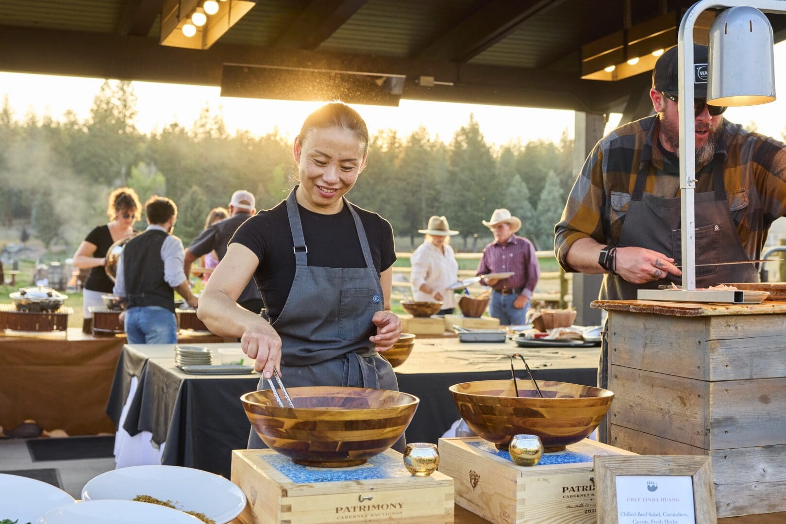 Chef cooking dishes outside in a buffet style manner.