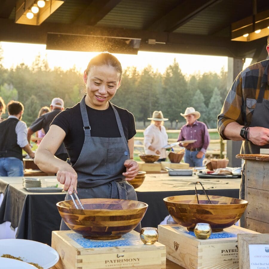 Chef cooking dishes outside in a buffet style manner.