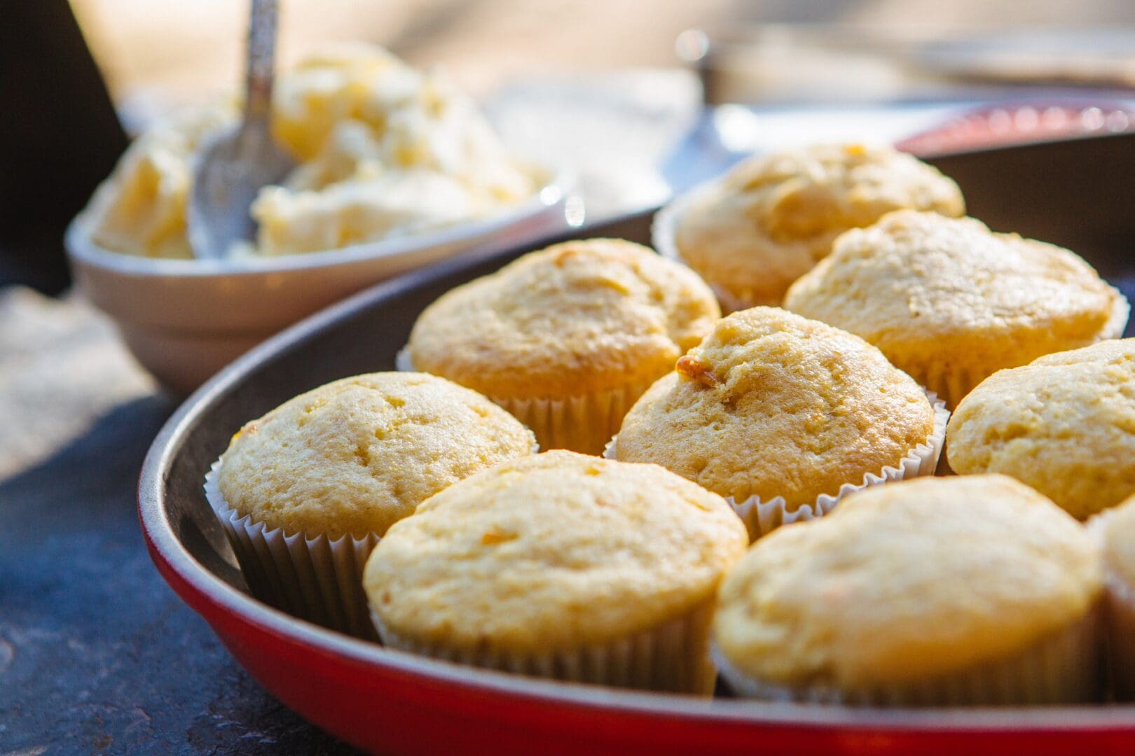 Closeup of a red plate holding cornbread muffins.