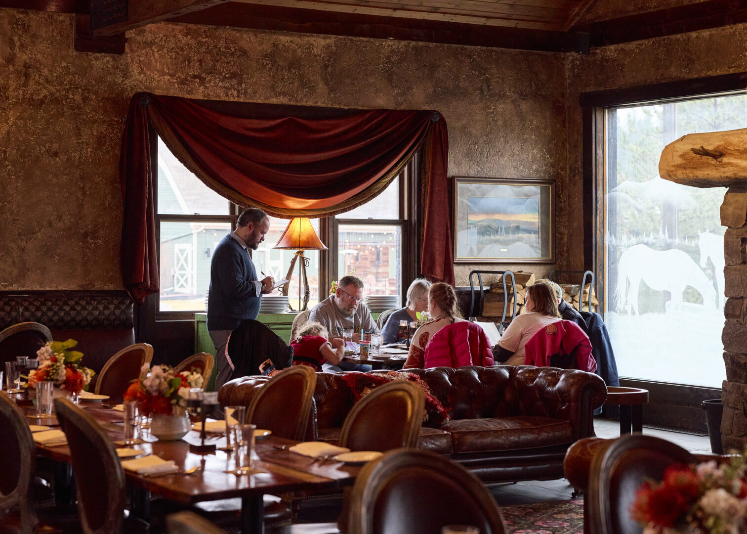Group of people sitting at a table at a western themed restaurant.