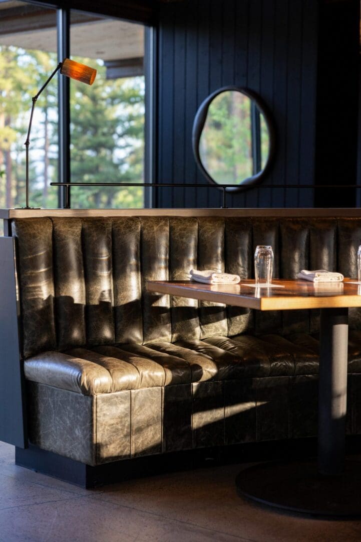 A leather booth inside of a dark restaurant.